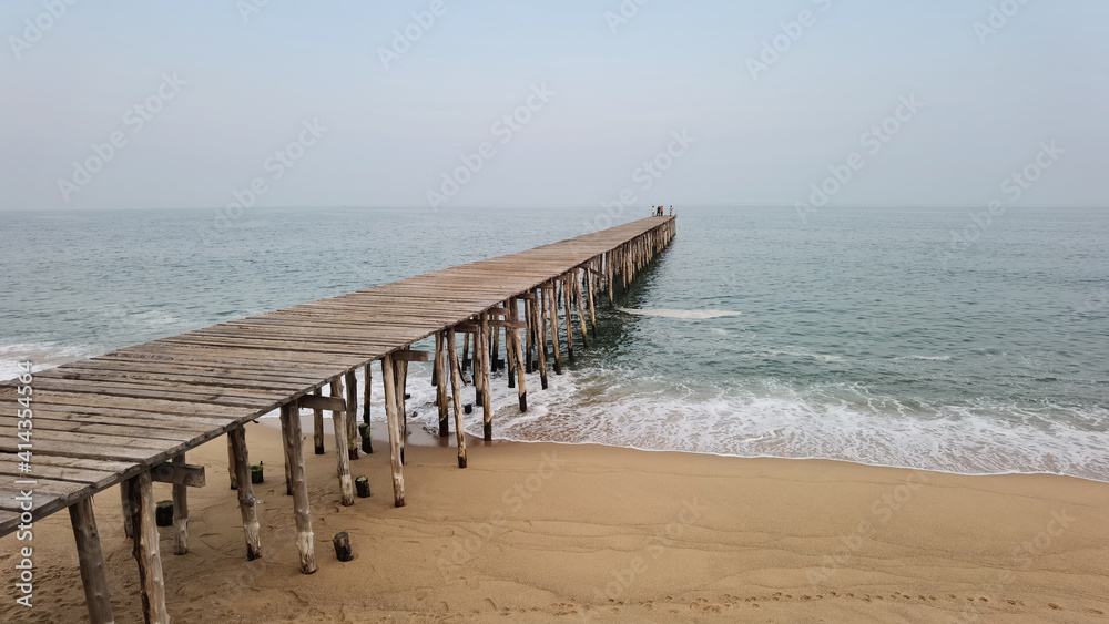Close up of wooden bridge to the sea with a beautiful sea