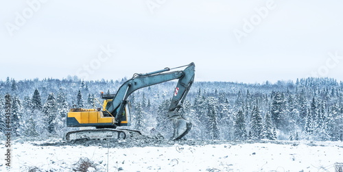 excavator works at a construction site in winter 