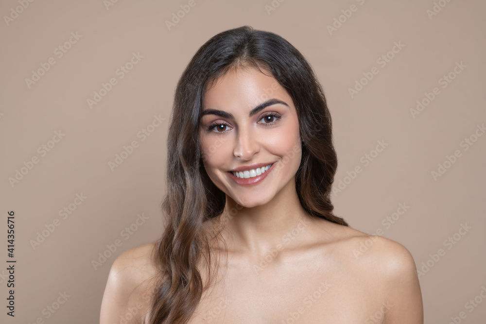 Smiling young adult woman with bare shoulders Smiling young adult woman with bare shoulders