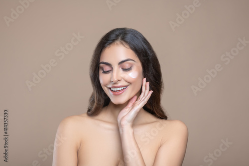 Woman with face cream and drooping eyelids