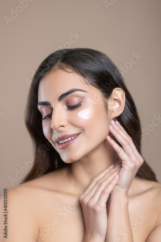 Woman with drooping eyelids and cream on cheeks