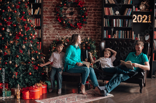 A family with three children decorates a Christmas tree