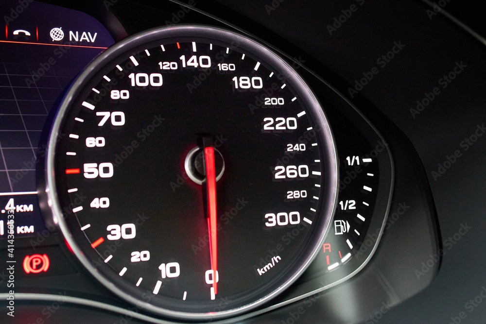 Electronic dashboard of modern luxury car view from aside. Speedometer shows speed in kilometers per hour and fuel control, parking and GPS system alert with copyspace.