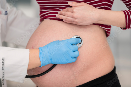 Doctor checking a pregnant woman with a stethoscope