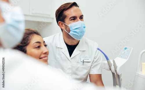 Happy dentist and female patient