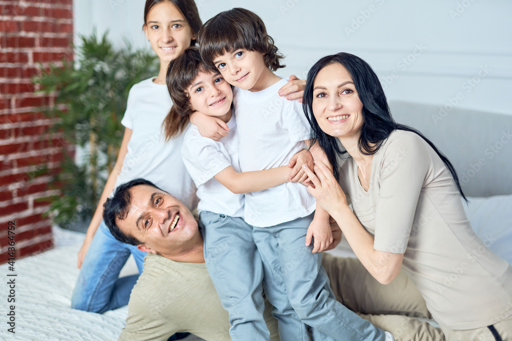 Family time. Portrait of happy latin family, parents and children smiling at camera while spending time together at home Family time. Portrait of happy latin family, parents and children smiling at camera while spending time together at home