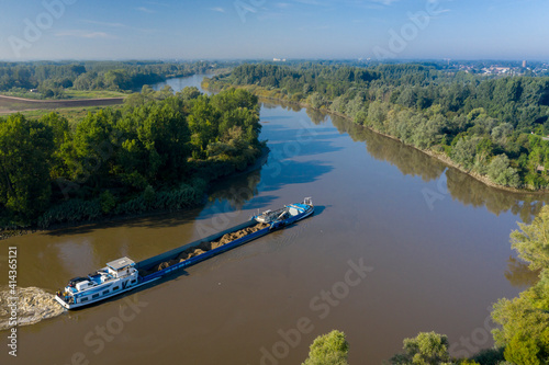 Moerzeke, Belgium - August 24 2019: Barge on Scheldt river, moments before executing a 90-degree turn photo