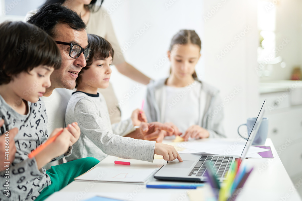 Happy latin father watching cartoons together with children in the morning while spending time with his family at home Happy latin father watching cartoons together with children in the morning while spending time with his family at home