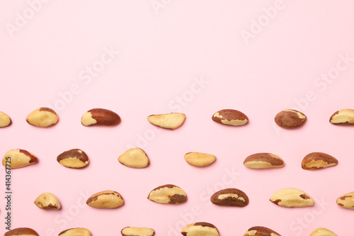 Flat lay with tasty brazil nuts on pink background