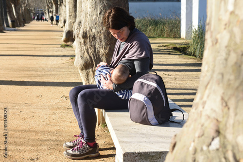mother in sportswear breastfeeding her child