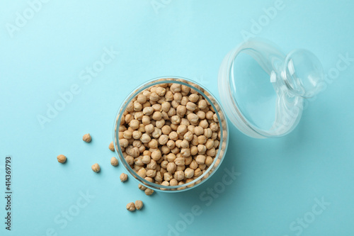 Glass jar with fresh chickpea on blue background