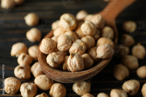 Spoon with fresh chickpea on wooden table