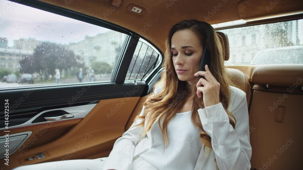 Apathetic business lady talking on mobile phone in salon of modern car. Apathetic business lady talking on mobile phone in salon of modern car.