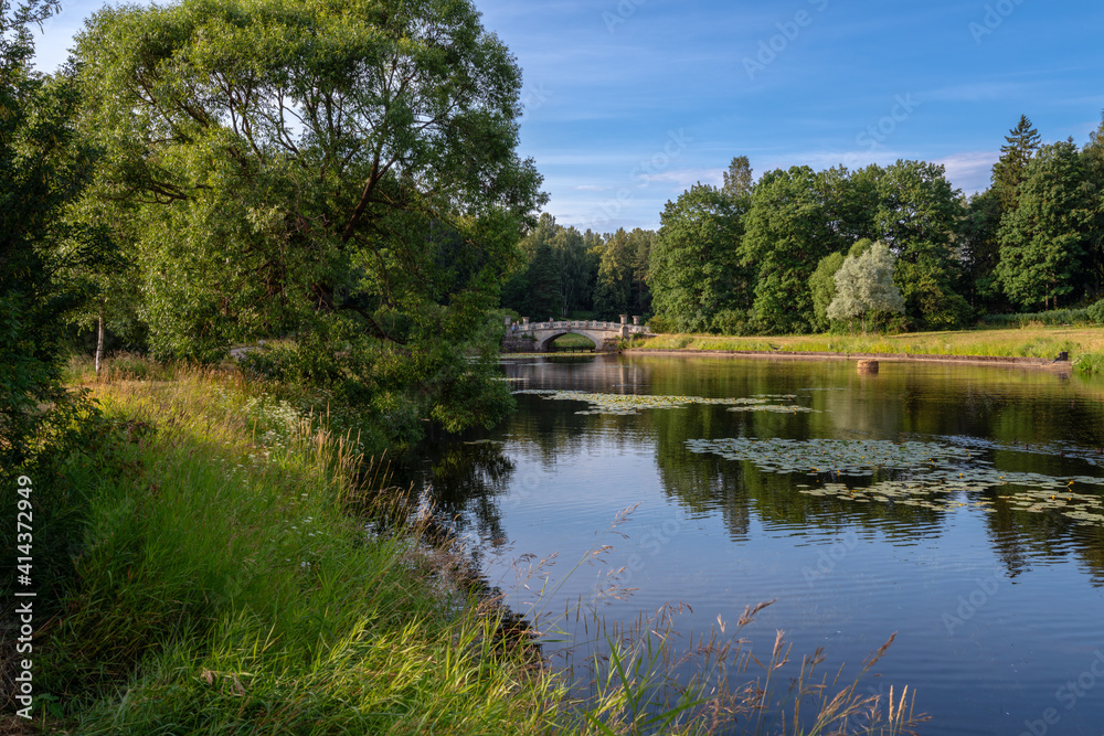 View of the Slavyanka River and the Viscontiev Bridge in the Pavlovsk Palace and Park Complex on a summer day, Pavlovsk, Saint Petersburg, Russia