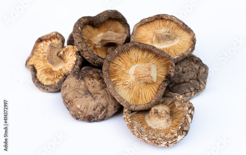 A pile of dried shiitake mushrooms on a white background.