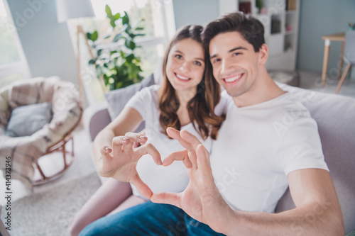 Portrait of cheerful spouse fingers show heart shape lovely harmony wear white style t-shirt spending time home indoors