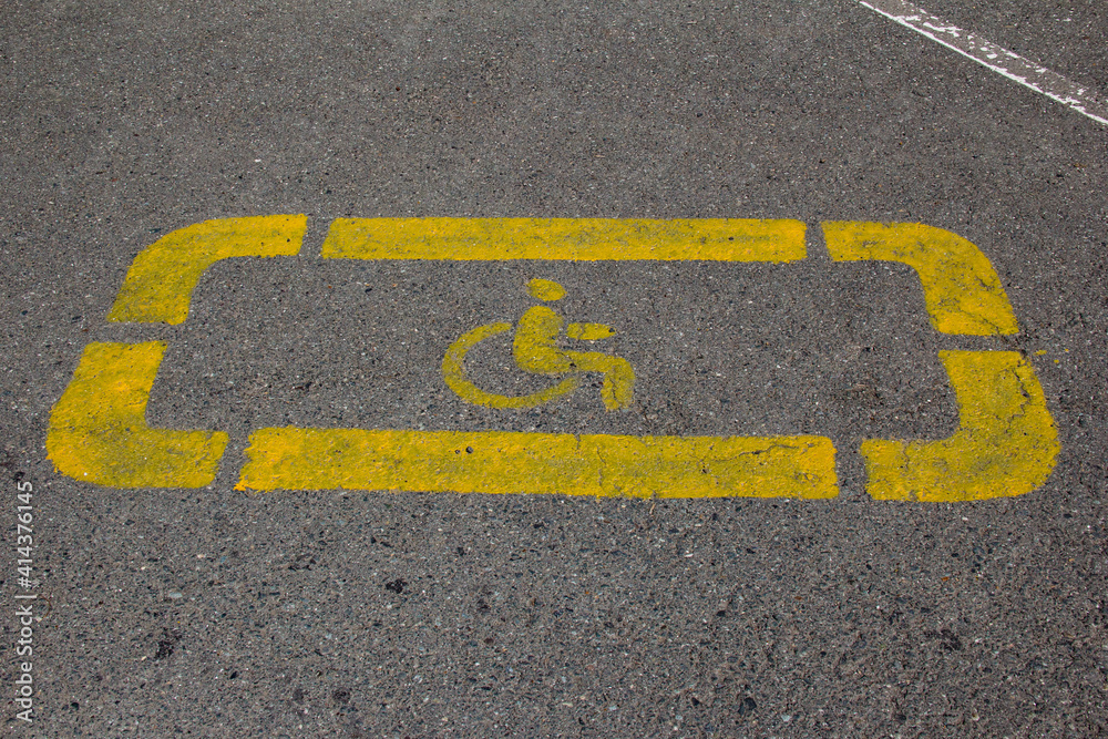 Fototapeta premium Disabled person sign applied to the parking space with yellow paint.