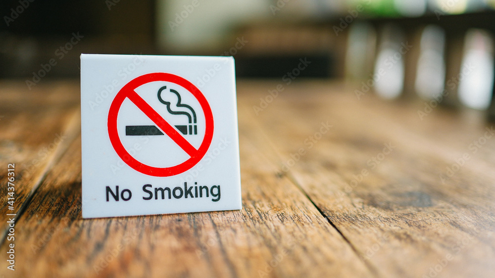 No Smoking label in the public. No smoking sign on wood table at hotel No Smoking label in the public. No smoking sign on wood table at hotel
