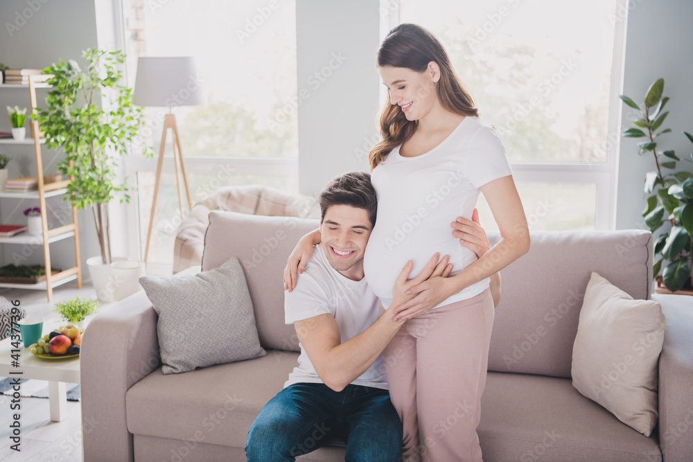 Portrait of nice affectionate dreamy cheery gentle spouses waiting baby guy listening tummy heart beat in light house flat indoor Portrait of nice affectionate dreamy cheery gentle spouses waiting baby guy listening tummy heart beat in light house flat indoor