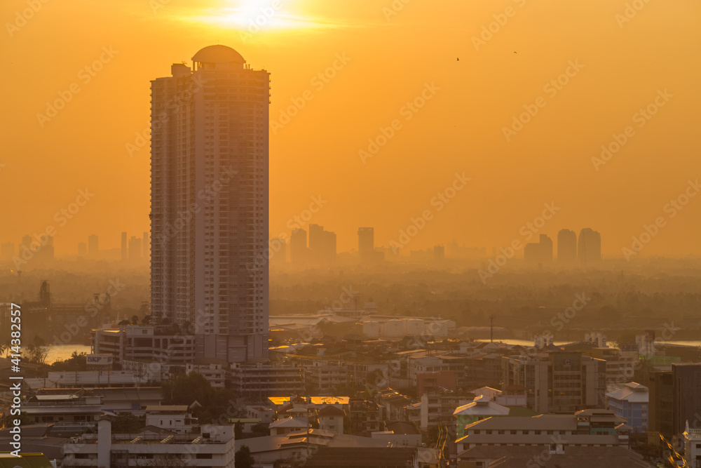 Fototapeta premium The blurred abstract background of the morning sun exposure to the tiny dust particles that surround the tall buildings in the capital, the long-term health issue of pollution