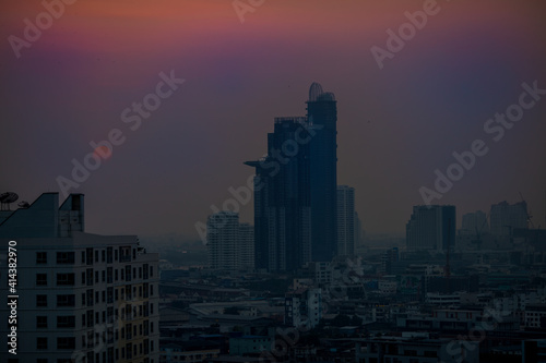 The blurred abstract background of the morning sun exposure to the tiny dust particles that surround the tall buildings in the capital, the long-term health issue of pollution