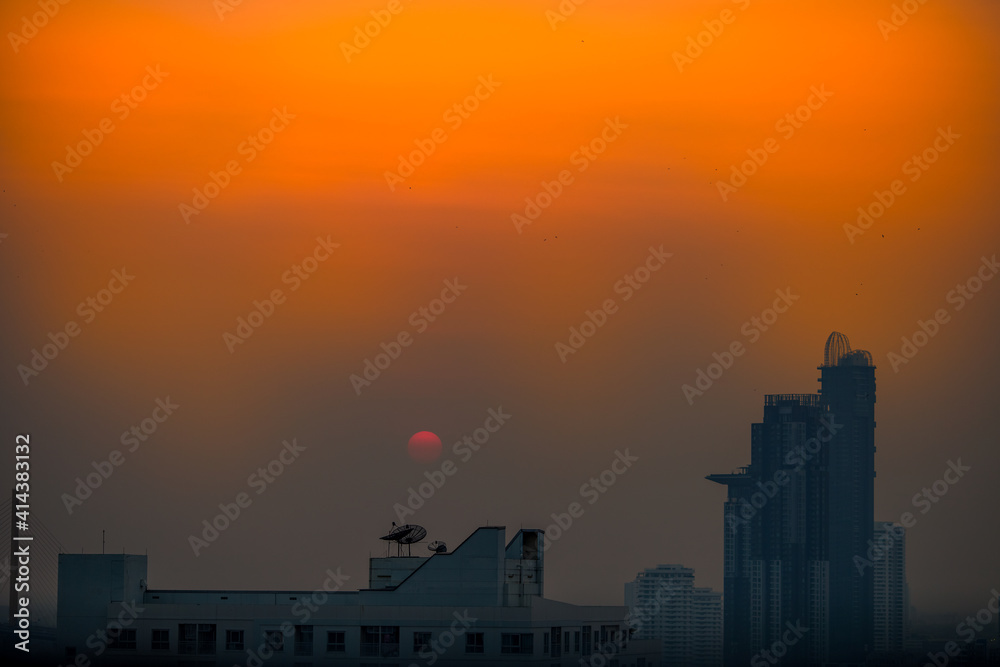 The blurred abstract background of the morning sun exposure to the tiny dust particles that surround the tall buildings in the capital, the long-term health issue of pollution