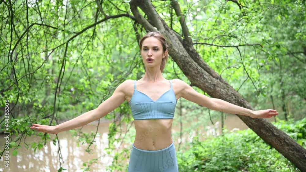 Young happy beautiful slim fit girl in blue sportswear workout doing morning exercise with fitness training gum in the summer green park outdoor. Girl with perfect body, sport yoga Young happy beautiful slim fit girl in blue sportswear workout doing morning exercise with fitness training gum in the summer green park outdoor. Girl with perfect body, sport yoga