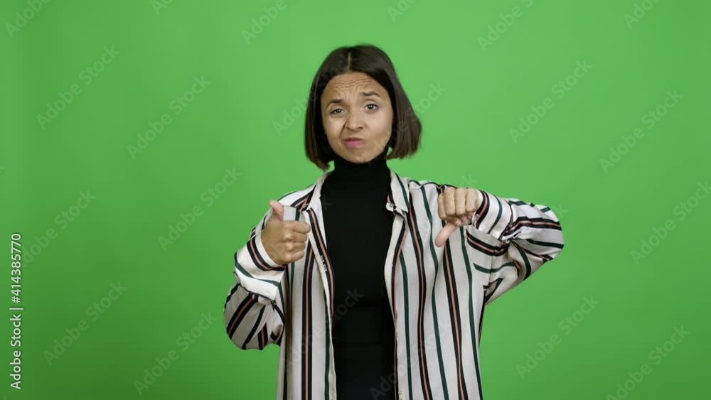Woman making good-bad sign over isolated background Woman making good-bad sign over isolated background