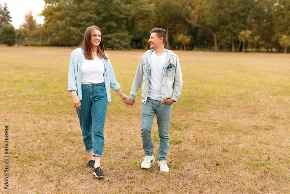 Cheerful young couple smiling and walking outdoor. Cheerful young couple smiling and walking outdoor.