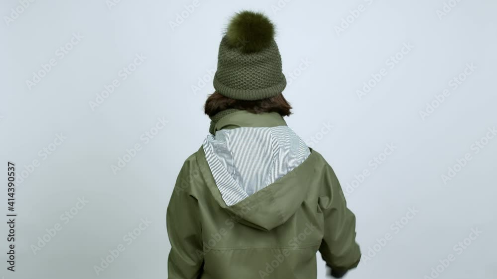 Woman with winter hat pointing back with the index finger over isolated background Woman with winter hat pointing back with the index finger over isolated background