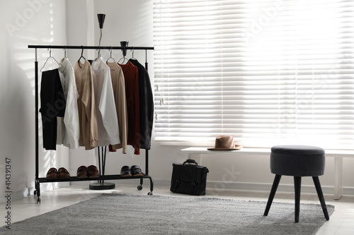Rack with stylish men's clothes indoors. Interior design © New Africa