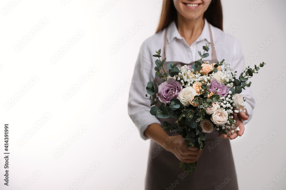 Florist holding beautiful wedding bouquet on white background, closeup Florist holding beautiful wedding bouquet on white background, closeup