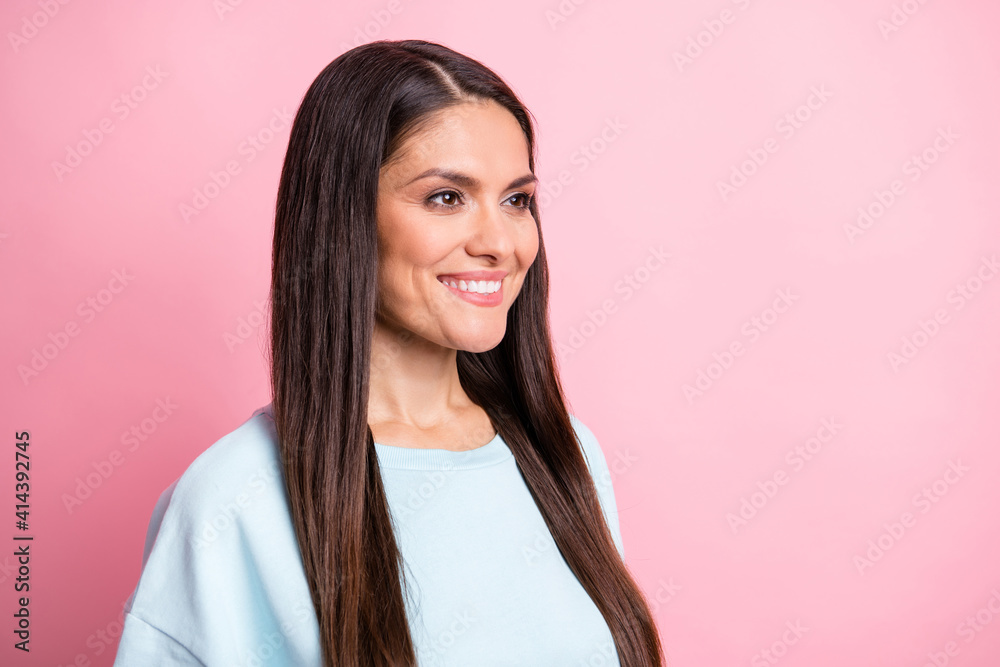 Photo portrait of smiling brunette in blue jumper looking blank space isolated on pastel pink color background Photo portrait of smiling brunette in blue jumper looking blank space isolated on pastel pink color background