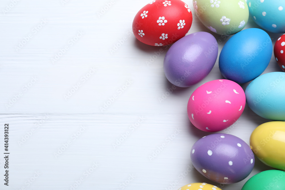 Bright painted eggs on white wooden table, flat lay with space for text. Happy Easter Bright painted eggs on white wooden table, flat lay with space for text. Happy Easter