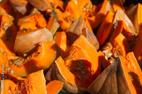 Photos slices of sunny orange squashes at market display in winter