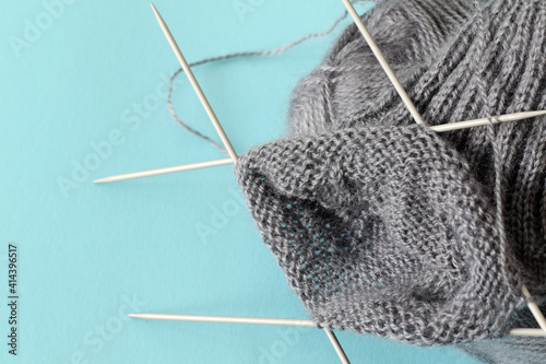 grey wool sock knitting with five needles photo