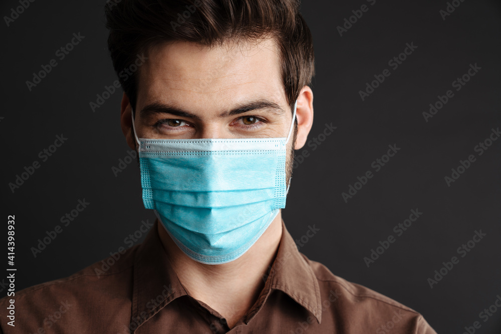Close up of a confident young man in medical protective mask Close up of a confident young man in medical protective mask
