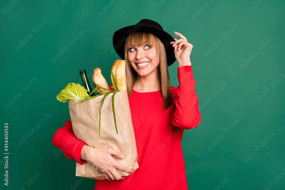 Photo of young attractive beautiful happy positive dreamy girl look copyspace hold bag with products isolated on green color background
