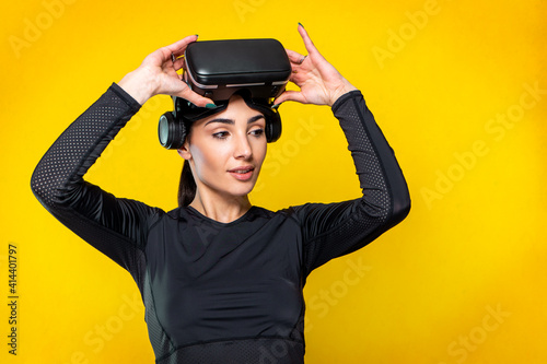 Studio shooting with pretty slim young sporty brunette athletic model girl posing during quarantine wearing hi tech futuristic vr glasses - young sportive attractive caucasian athlete sports woman