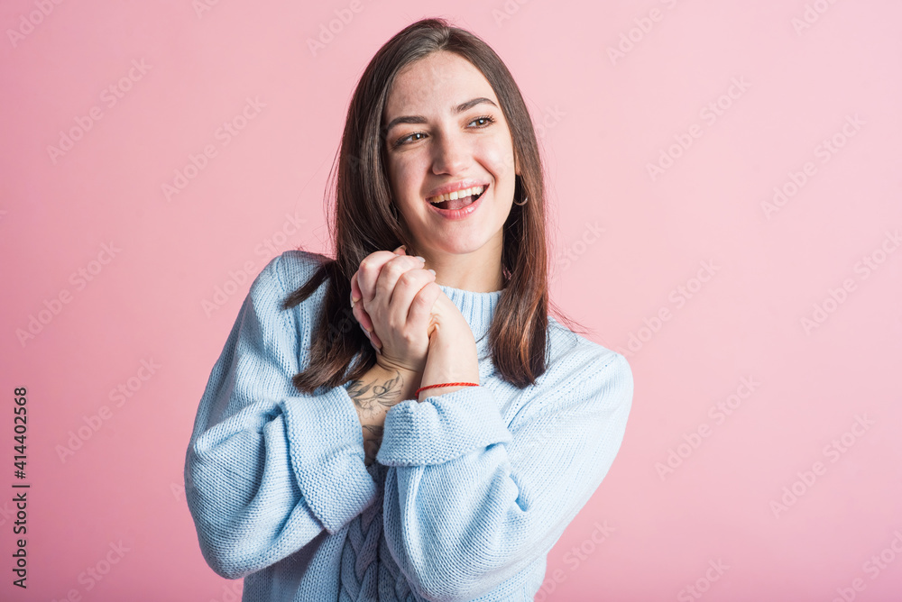 Smiling and happy brunette girl in studio on pink background