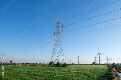 High voltage Electric pole with green rice farm in day time