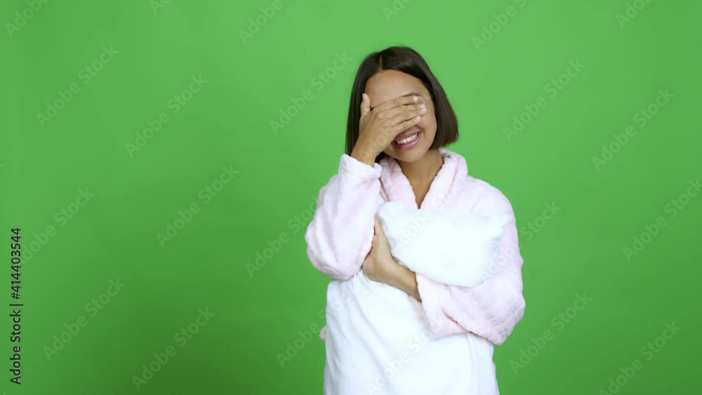 Woman in pajamas covering eyes by hands. Surprised to see what is ahead over isolated background Woman in pajamas covering eyes by hands. Surprised to see what is ahead over isolated background
