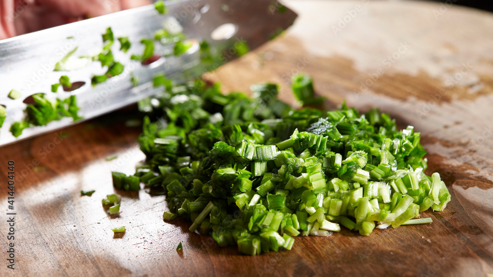 Cooked chopped chives on a wooden board Cooked chopped chives on a wooden board