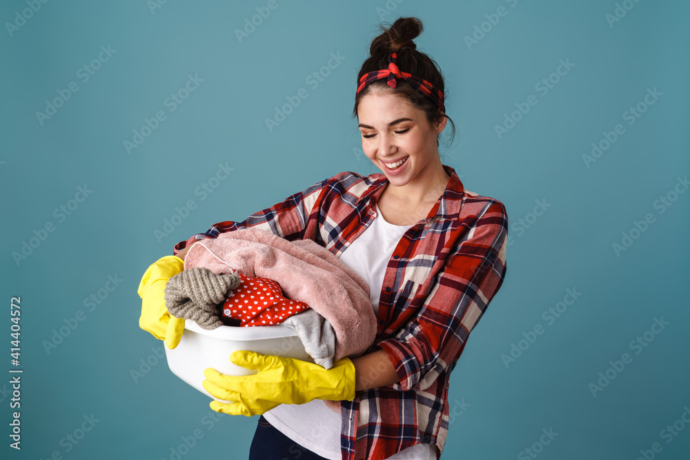 Happy beautiful girl in gloves smiling while posing with dirty clothes Happy beautiful girl in gloves smiling while posing with dirty clothes