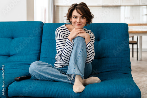 Happy beautiful woman smiling while sitting on couch