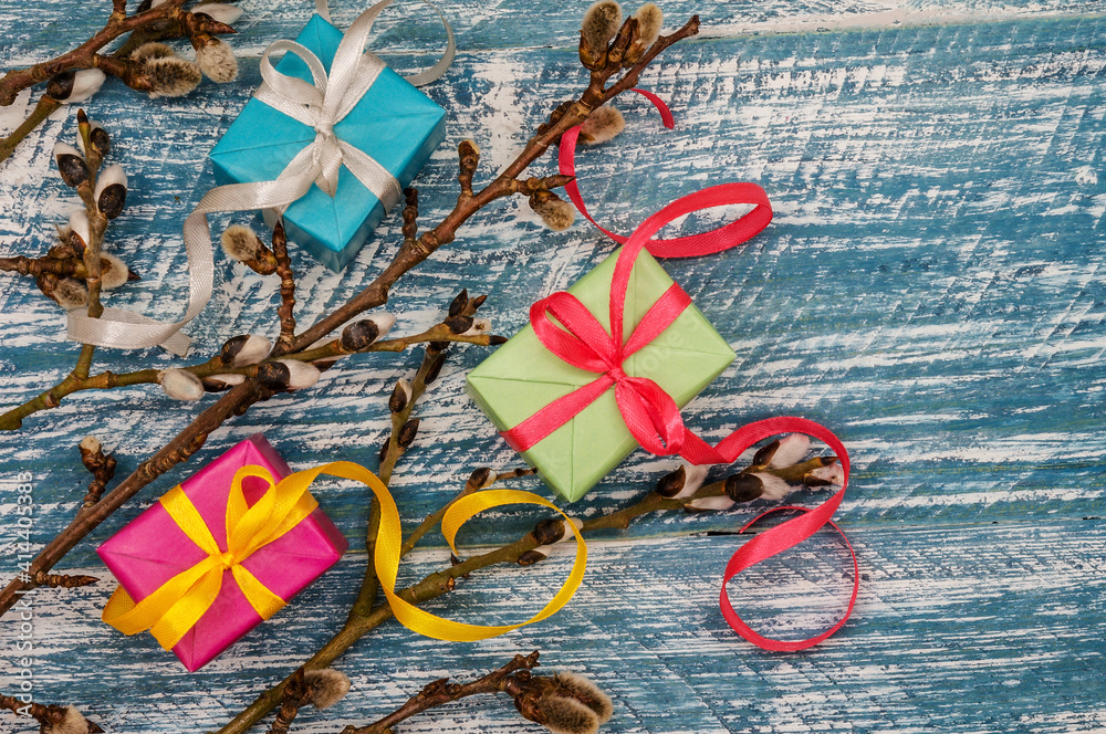 Naklejka premium Gift boxes with origami ribbons. Willow twigs. Holy Easter. Blue turquoise background.