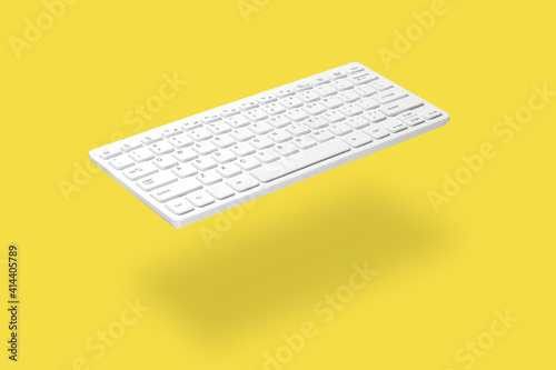 . White computer keyboard levitating on yellow background, shadow visible. The concept of modern digital technologies, online work, training, sales, etc.