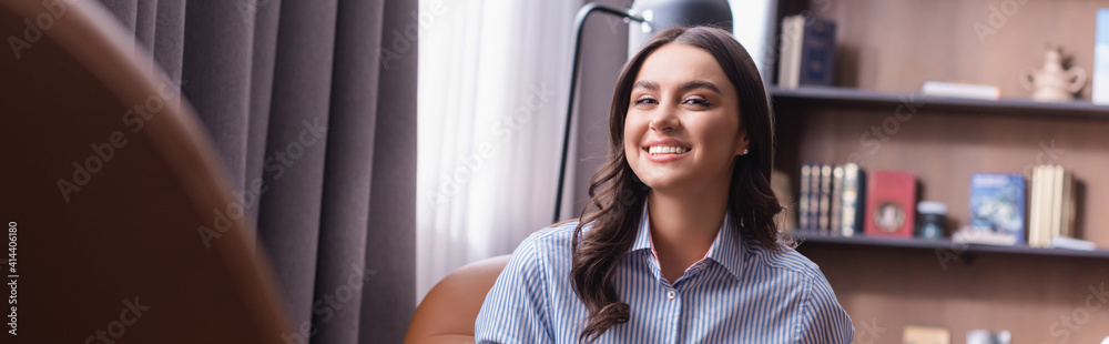 happy young businesswoman smiling at camera in restaurant on blurred foreground, banner happy young businesswoman smiling at camera in restaurant on blurred foreground, banner
