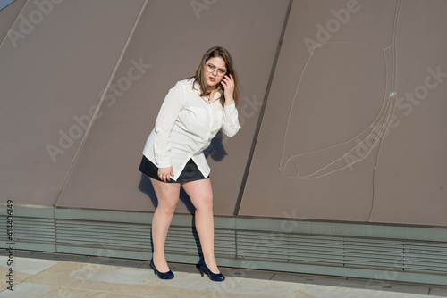 Latin woman with long hair in white shirt and black skirt