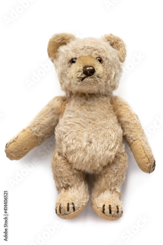 niedlicher Teddybär, Kinder Spielzeug, sehr alt und abgenutzt, gebraucht. Auf weißem Hintergrund, liegend
